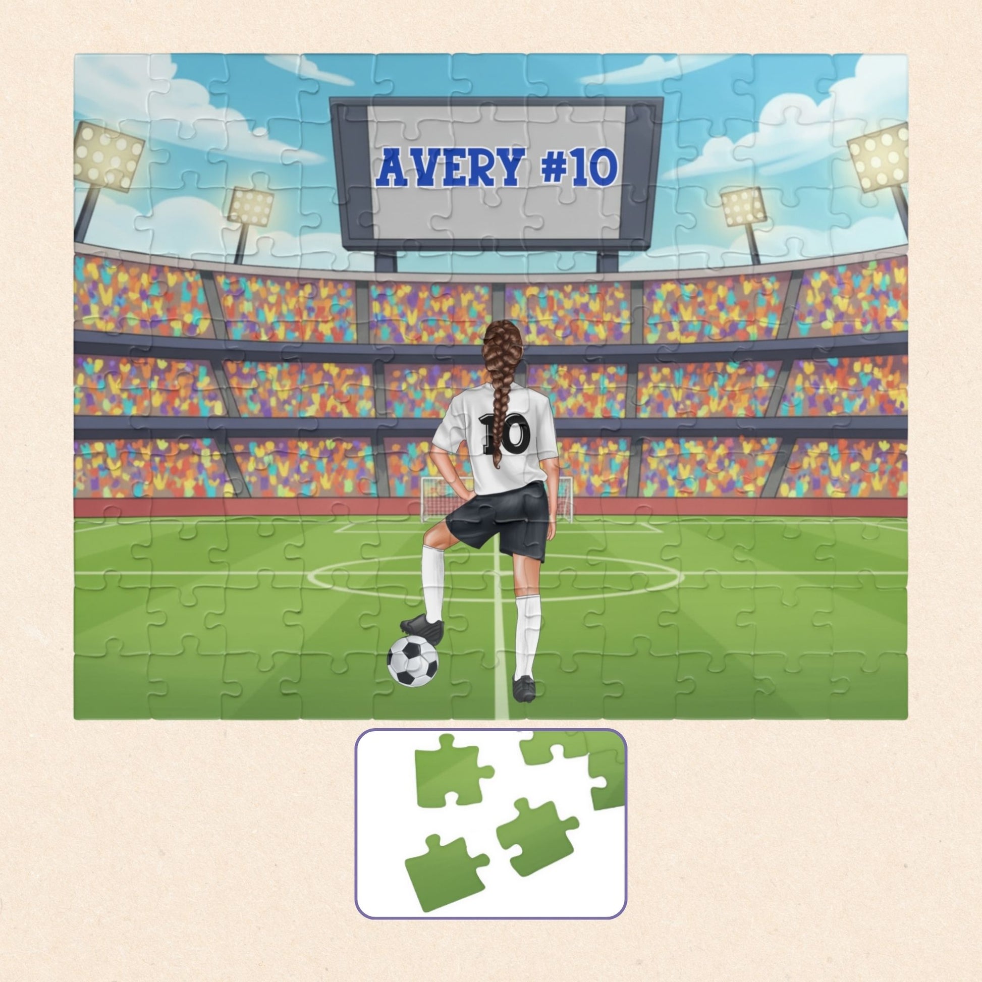 Personalized girls soccer jigsaw puzzle showing a player standing on a soccer field in a stadium, with a customizable name displayed on the scoreboard above and a customizable number on the back of the jersey. Hair color and player style can be selected.