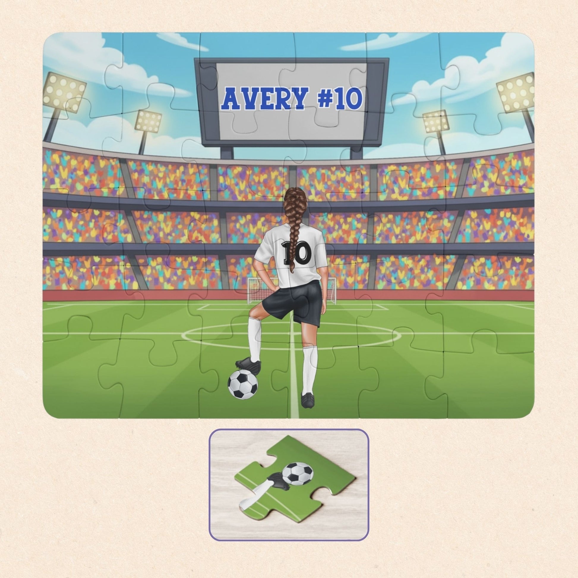 Personalized girls soccer puzzle showing a young player standing on a soccer field inside a large stadium, resting one foot on a soccer ball. The back of the jersey displays a customizable name and number, and a stadium scoreboard above also shows the personalized name and number.