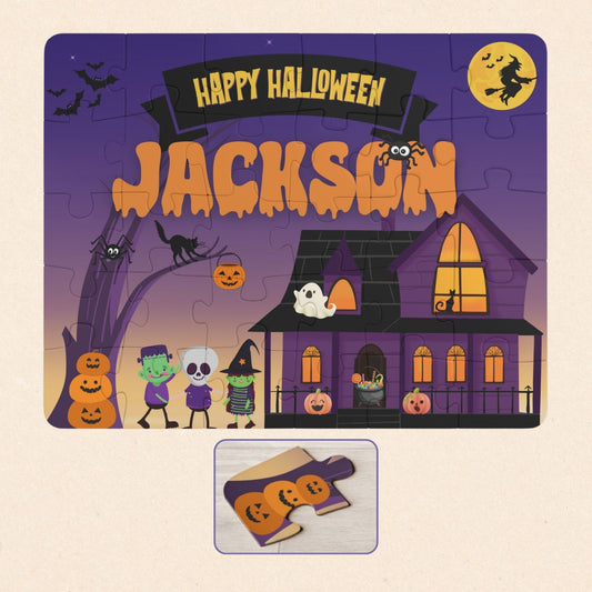 Personalized Halloween kids puzzle featuring a spooky haunted house scene with trick-or-treaters, pumpkins, bats, and a purple night sky. The puzzle includes a customizable child’s name displayed across the top and is a 30-piece jigsaw designed for young children.