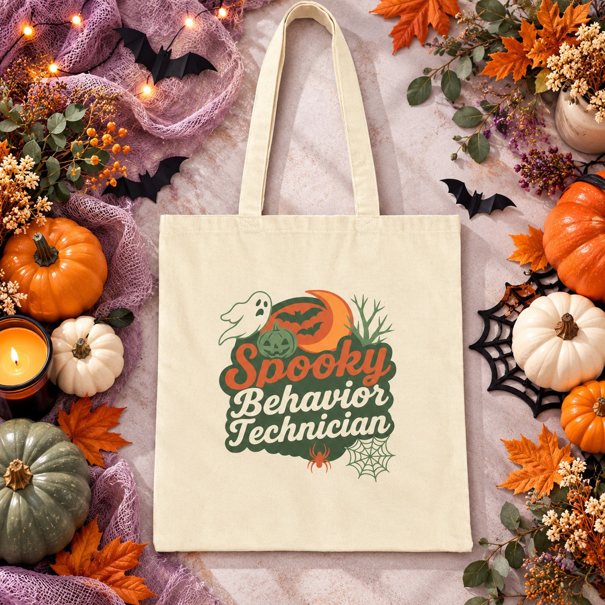 Natural canvas tote bag featuring a Halloween-themed design that reads “Spooky Behavior Technician,” with a ghost, pumpkin, crescent moon, bats, spider, and spiderweb, styled in warm fall colors and displayed against a festive Halloween background.