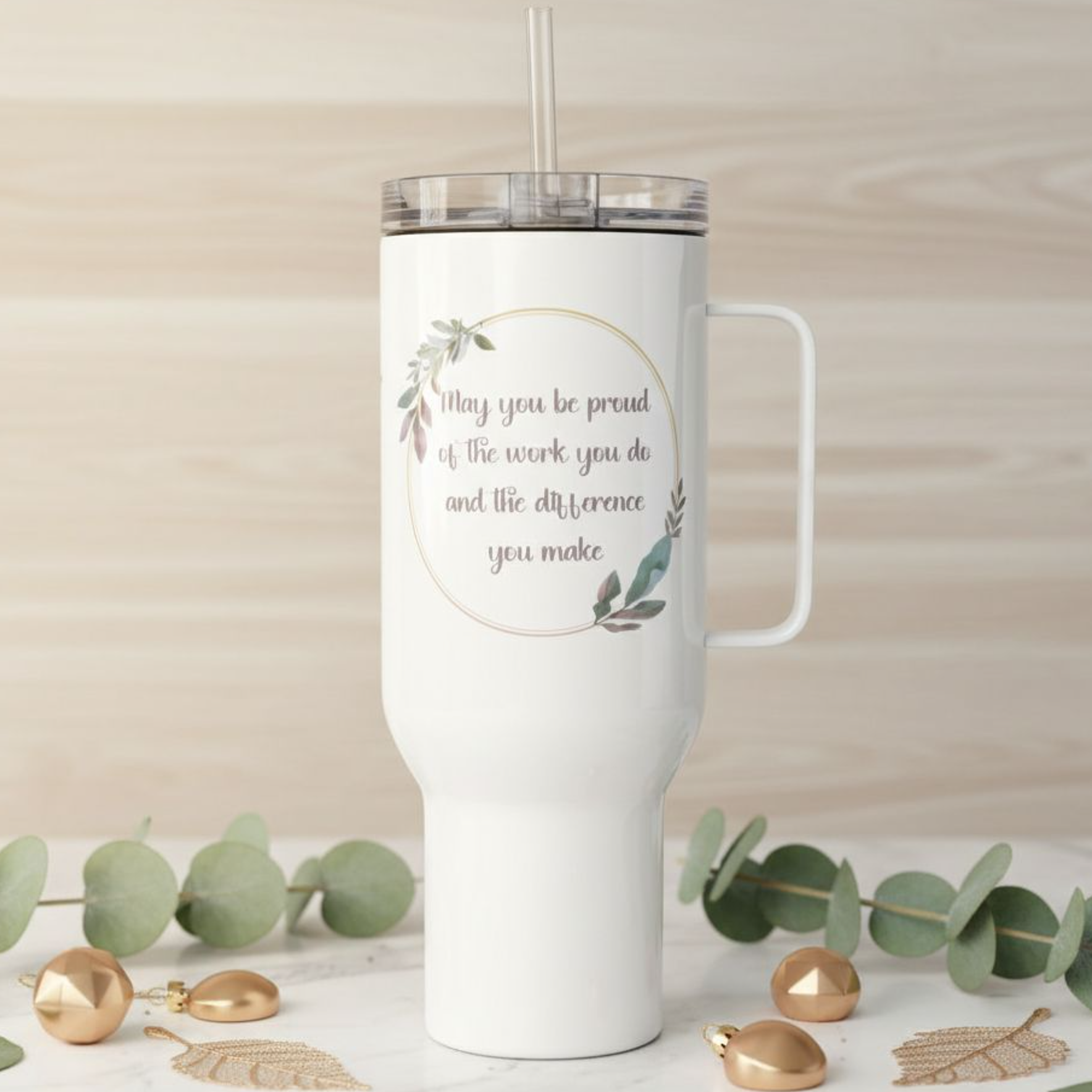 White 40 oz travel tumbler with handle and straw lid, displaying a soft floral quote design on the front with a customizable name printed on the side, photographed in a neutral home setting with woven and botanical accents.